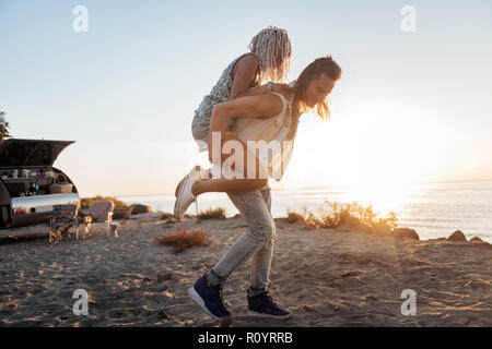 Starke liebevoller Mann seine Freundin in die Arme zu Fuß am Strand Stockfoto