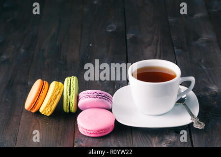 Tasse Kaffee und französischen Macaron an einem alten Holztisch Stockfoto