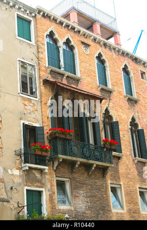 Venedig, Palast mit maurischen Fenster und Balkon mit roten Blumen Stockfoto