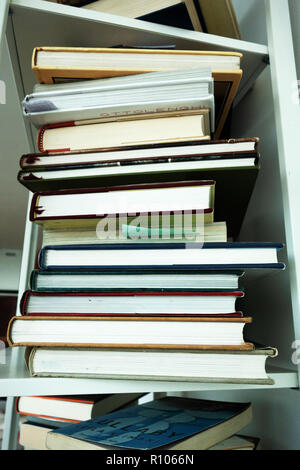 Foto der Seiten eines Haufen gegengezeichnet Bücher auf ein weißes Regal, keine Kopie Stockfoto