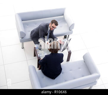 Zwei Geschäftsleute über Aufgaben im Büro sitzen. Stockfoto