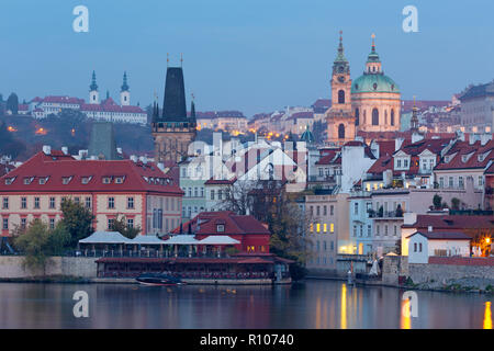 Prag - St.Nikolaus-Kirche auf der Kleinseite, gotische Turm der Karlsbrücke und Strahov Kloster im Hintergrund von Morgen. Stockfoto