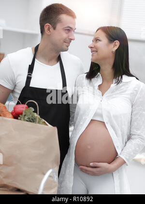 Mann und seine schwangere Frau sind Kämmen durch die Pack, stehen in der Küche Stockfoto