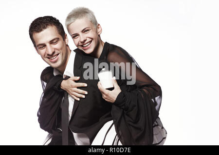 Ein Mädchen mit einem kurzen Haarschnitt sitzt auf der Kerl zurück, mit Kaffeetassen auf einem weißen Hintergrund. Kaffee trinken gehen. Werbung. Stockfoto