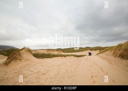 Wanderer zu Fuß durch Sanddünen auf Farraid Kopf, in der Nähe von Durness, Sutherland, Schottland, UK. Stockfoto