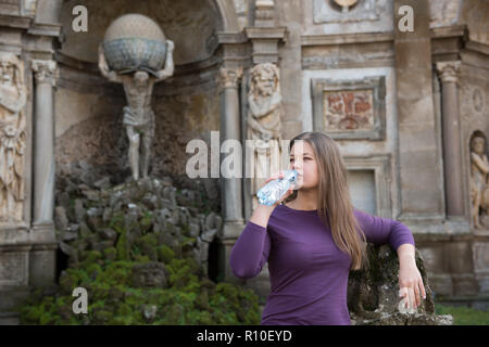 Junge Frau in Villa Aldobrandini, Frascati, Italien, vor antiken Fontain, Trinkwasser Stockfoto