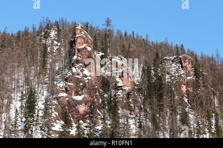 Rötlich verwitterten Felsen im südlichen Jakutien, Russland, im Winter Stockfoto