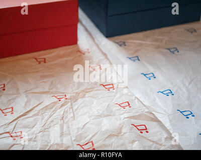 Zwei Arten von Verpackung Papier mit Einkaufswagen und zwei Boxen mit passenden roten und blauen Farben. closeup Schuß Stockfoto