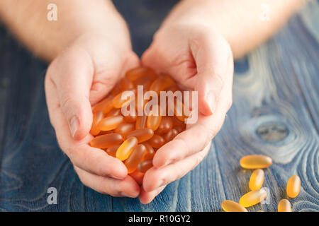 Haufen softgel Fischöl in der Menschen Hände Stockfoto