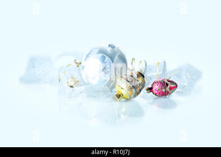 Reich verzierte Christbaumkugeln und Farbband auf weiße Oberfläche Stockfoto