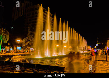 Die Leute, die auf der Suche am Brunnen mit Nachtlicht Stockfoto