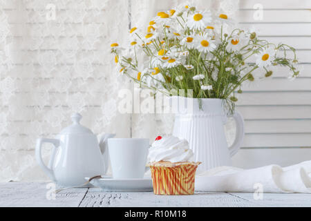 Frische Oxeye Gänseblümchen auf Tisch in weißem Krug im Innenraum Stockfoto