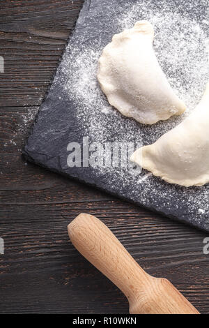 Vorbereitung, Kochen, die hausgemachten Ravioli, maultaschen oder Knödel mit Fleisch auf Holztisch, Ansicht von oben Stockfoto