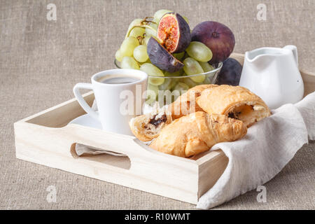 Frühstück im Bett, mit Obst und Gebäck auf einem Tablett Stockfoto