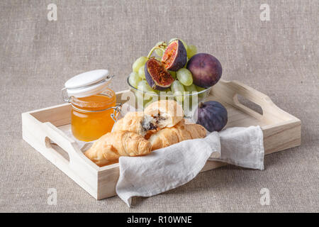 Frühstück im Bett, mit Obst und Gebäck auf einem Tablett Stockfoto