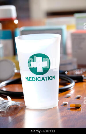 Kunststoff Medikation Tumbler auf Doctor's Table Top Stockfoto