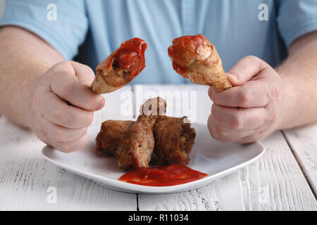 Kaukasische Mann mit Eröffnung Mund über frittierte Hähnchenkeulen oder drumsticks zu essen Stockfoto