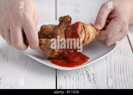 Kaukasische Mann mit Eröffnung Mund über frittierte Hähnchenkeulen oder drumsticks zu essen Stockfoto