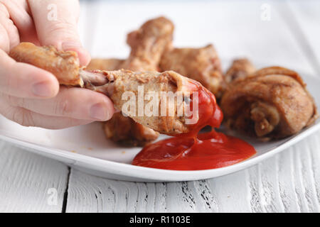 Kaukasische Mann mit Eröffnung Mund über frittierte Hähnchenkeulen oder drumsticks zu essen Stockfoto