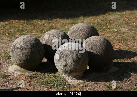 Alte steinerne Kanonenkugeln auf dem Boden liegen. Stockfoto