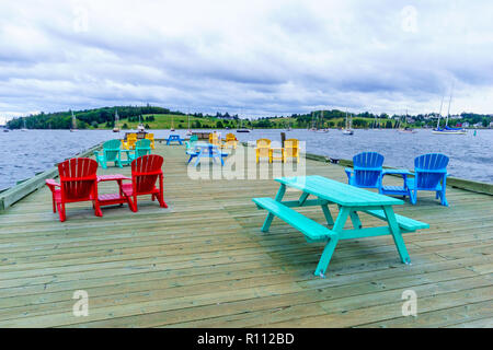 Lunenburg, Kanada - 21 September 2018: Pier mit bunten Stühlen, mit Touristen, in den Hafen von Lunenburg, Nova Scotia Stockfoto