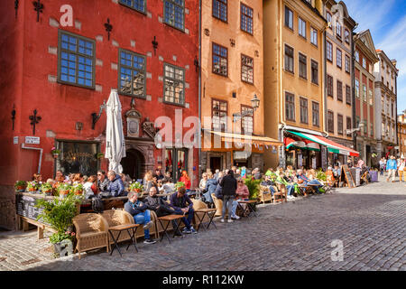 18. September 2018: Stockholm, Schweden - Touristen genießen die Sonne vor den Cafés und Restaurants von Stortorget, dem ältesten Platz im alten... Stockfoto