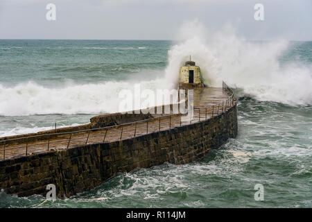 Portreath, Cornwall, UK. 04.11.2018. Gale force Winde bringen gigantische Surf schwillt zu Kornische Hafenstadt Portreath. Stockfoto