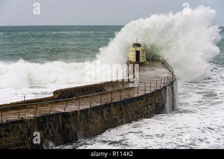 Portreath, Cornwall, UK. 04.11.2018. Gale force Winde bringen gigantische Surf schwillt zu Kornische Hafenstadt Portreath. Stockfoto