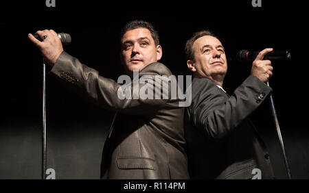 Zwei männliche Swing Jazz Sänger unter den Scheinwerfer mit Mikrofonen auf der Bühne. Stockfoto