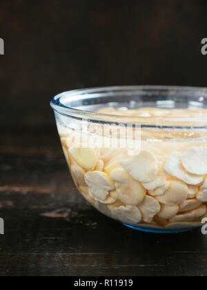 Getrocknete split fava Bohnen werden in Wasser eingeweicht. Stockfoto