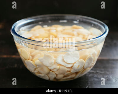 Getrocknete split fava Bohnen werden in Wasser eingeweicht. Stockfoto