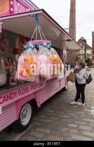 Einem Straßenhändler verkaufen Zuckerwatte und Popcorn aus einer umgebauten Rosa van am Albert Dock in Liverpool Stockfoto