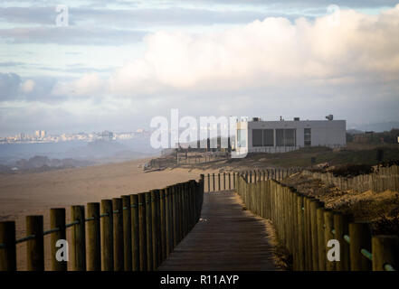 Weitwinkelaufnahme eines boardwalk Vollendung bis auf einen Sandstrand. Bewölkten Tag. Stockfoto