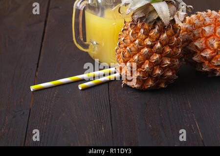 Ananassaft und Ananas auf einen hölzernen Tisch Stockfoto
