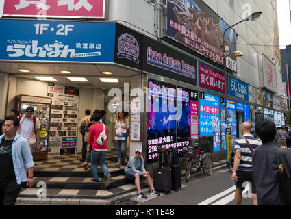 Menschen gehen in Akihabara, Tokio, Japan. Es ist ein beliebter Ort für Elektronik, Anime, Manga kaufen und hat viele Maid Cafes. Stockfoto
