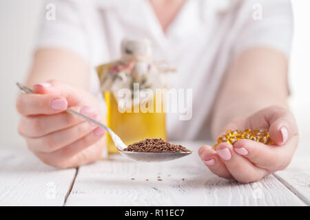 Leinsamen Kapseln und Öl in der Flasche auf Holz- Hintergrund Stockfoto
