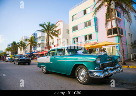 MIAMI - ca. Januar 2018: eine Linie von klassischen Autos stehen auf der Vorderseite des kultigen bunten Art Deco Architektur am Ocean Drive geparkt. Stockfoto