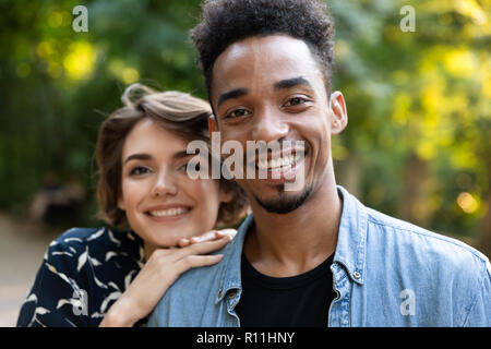 Nahaufnahme von lächelnden Jungen multiethnischen Paar umarmen im Freien Stockfoto
