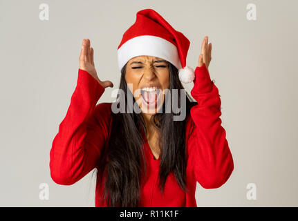 Porträt einer betonte Mädchen mit Red Hat auf der Suche verzweifelt und wütend Gesten auf neutralem Hintergrund in Weihnachten isoliert kommt nicht buyi Stockfoto