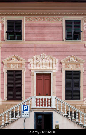 Fensterläden aus Holz sind mit Trompe-l'oeil-Säulen, Balustraden und Rahmen auf diesem Gebäude in Sestri Levante eingerichtet. Stockfoto