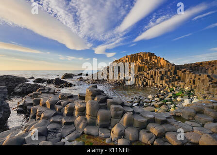 Nordirland, County Antrim, Giants Causeway, dramatische cloud Muster über die Felsen bei Sonnenuntergang. Stockfoto