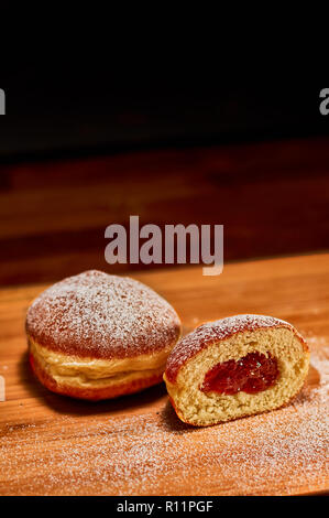 Frisch zubereitete Konfitüre gefüllt Donuts auf Holz Schneidebrett. Sehr geringe Tiefenschärfe Stockfoto