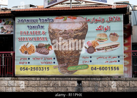 Ein dreisprachiges Schild Werbung für ein lokales Restaurant in Nazareth Israel in Arabisch, Englisch und Hebräisch. Stockfoto