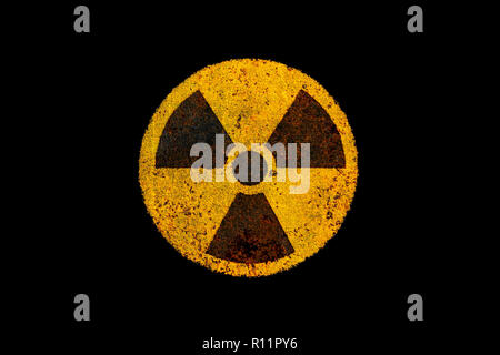 Runde gelbe und schwarze Radioaktivität (ionisierende Strahlung) nukleare Gefahr Symbol auf rostiges Metall grungy Textur und isoliert auf dunklen schwarzen Hintergrund. Stockfoto