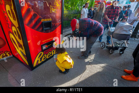 Candy Liebhaber exchange unerwünschte Süßigkeit an der Reese' Candy Exchange Automaten' außerhalb von Washington Square Park in New York am Mittwoch, 31. Oktober 2018. Indem sie ihre unerwünschten Candy in den Schlitz der Maschine liefert die entsprechende Menge von Reese's Peanut Butter Cups. Nach einer Umfrage, zusammentreffend im Auftrag von Reese's, 90 % aller Amerikaner wurden mit einigen der Süßigkeit, die Sie während Ihres Halloween Trick empfangen oder Behandlung unzufrieden und würde Ihnen gerne für die mehr köstliche Reese's Peanut Butter Cups. Reese's ist eine Marke der Hershey Company. (Â© Richard B. Stockfoto