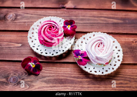 Süße Nachspeise weiß, rosa Zephyr Marshmallows auf Lehm Platte und rustikalen Holzmöbeln Hintergrund. Eibisch, Baiser, Zephyr. Selektive konzentrieren. Platz kopieren Stockfoto