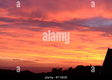 Sonnenuntergang auf Mumbles. Die untergehende Sonne verschwindet unter dem Horizont verursacht atmosphärische Refraktion erstellen die schöne Spektrum der Farben in den Himmel. Stockfoto