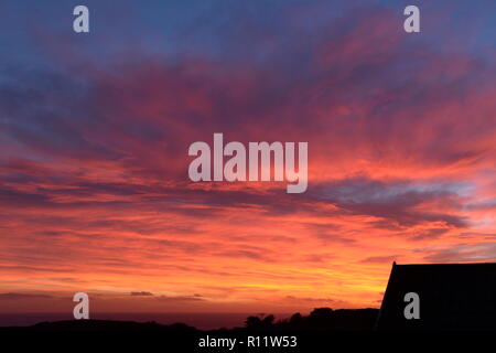 Sonnenuntergang auf Mumbles. Die untergehende Sonne verschwindet unter dem Horizont verursacht atmosphärische Refraktion erstellen die schöne Spektrum der Farben in den Himmel. Stockfoto