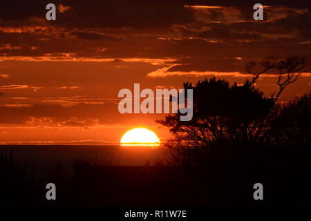 Sonnenuntergang auf Mumbles. Die untergehende Sonne verschwindet unter dem Horizont verursacht atmosphärische Refraktion erstellen die schöne Spektrum der Farben in den Himmel. Stockfoto