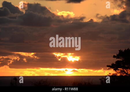 Untergehende Sonne auf Mumbles, Gower, erzeugt einen schönen farbigen Himmel von einzigartigen atmosphärischen Bedingungen, die intensiven Farben Orange und Rot Stockfoto